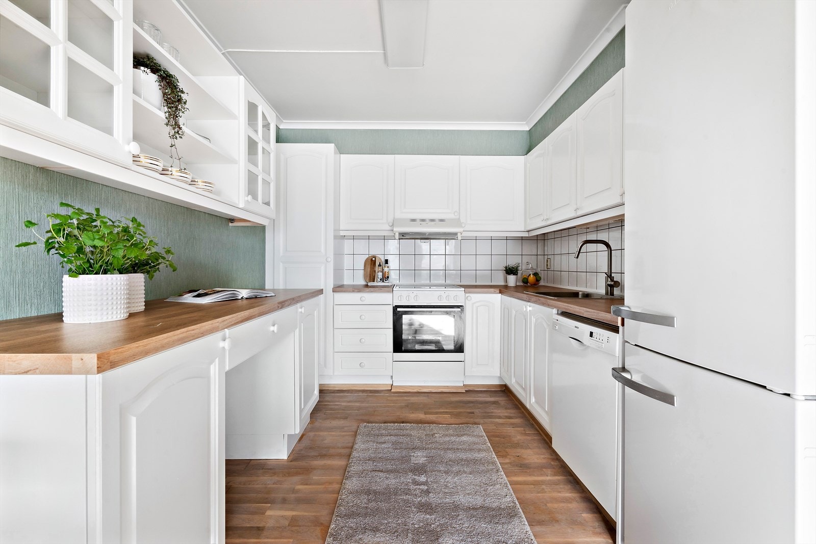 Gode arbeidsflater og praktisk plassering av de ulike elementene gjør dette til et hyggelig sted for matlaging. Galleribilde