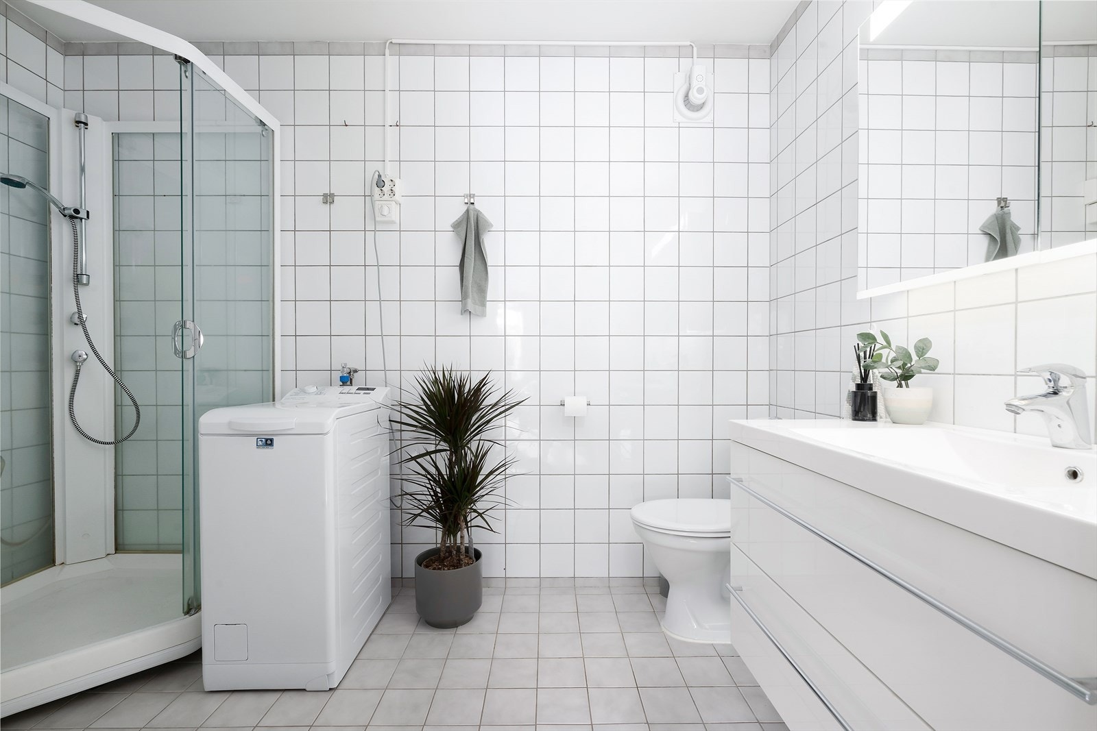 Lyst og tidløst bad med flislagte flater og elektriske varmekabler. Galleribilde