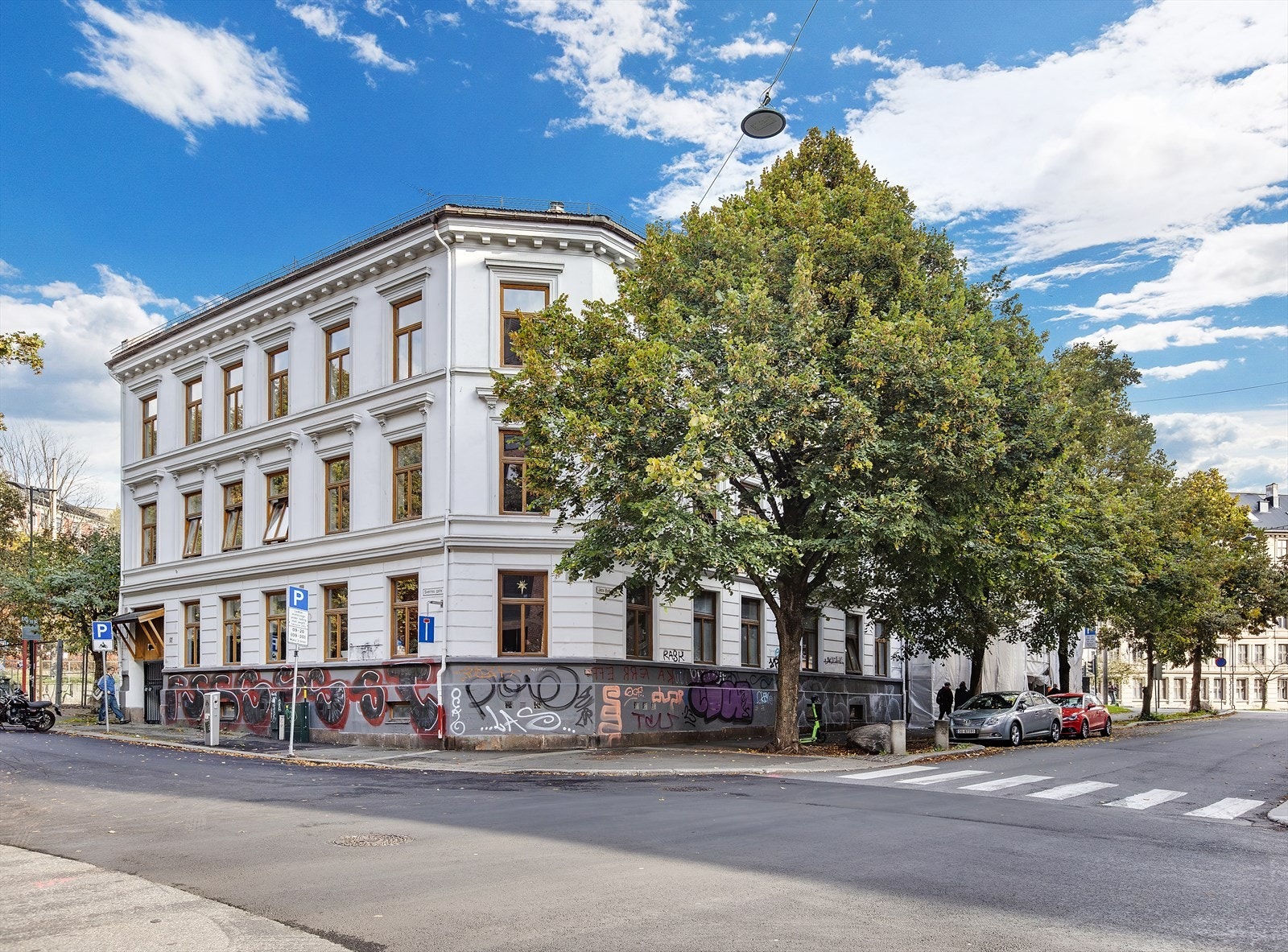 Treetasjes hjørnebygg med historisk uttrykk og tydelig tilstedeværelse i bybildet Galleribilde