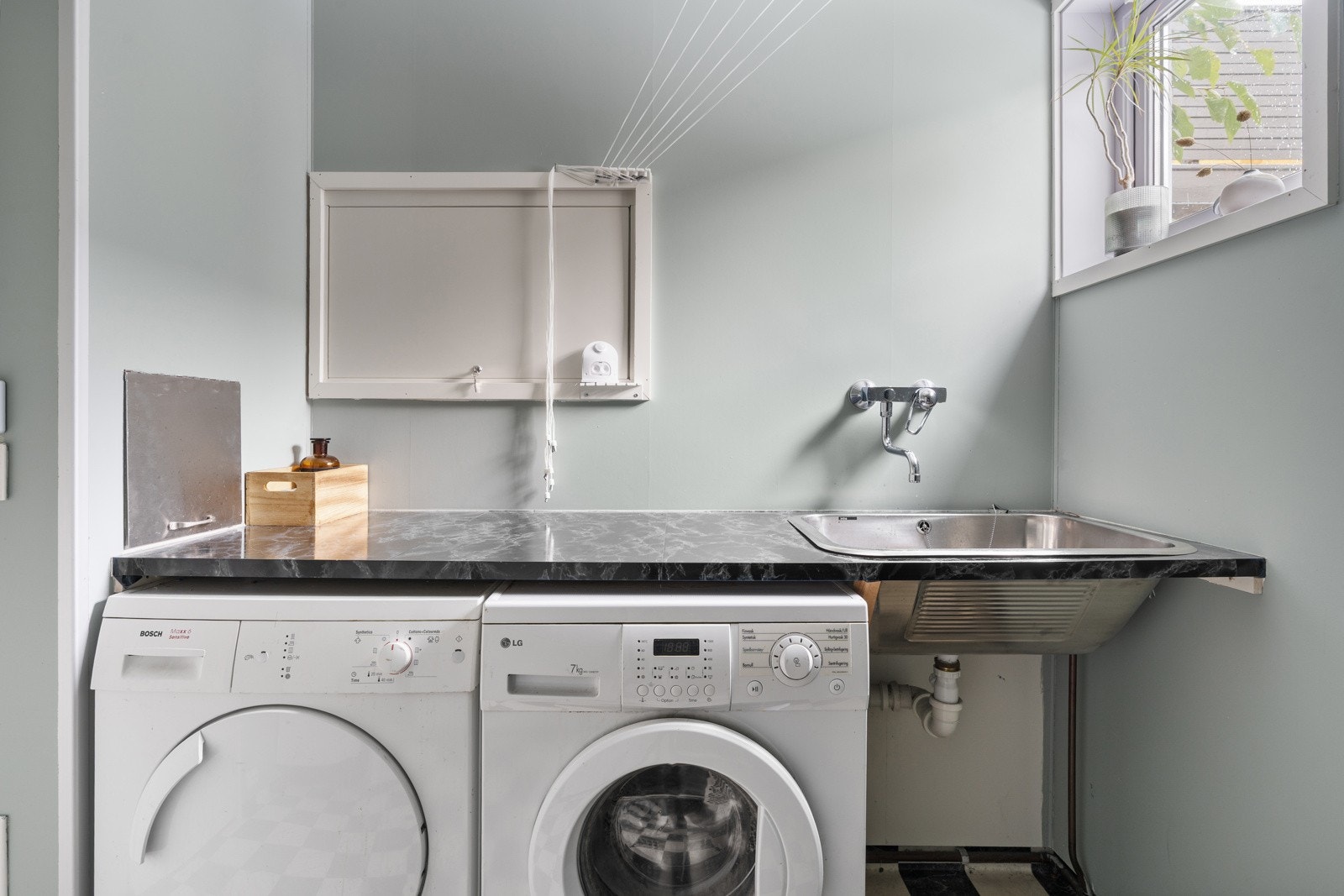 Svært praktisk vaskerom med plass for både vaskemaskin og tørketrommel samt arbeidsplass på benk.