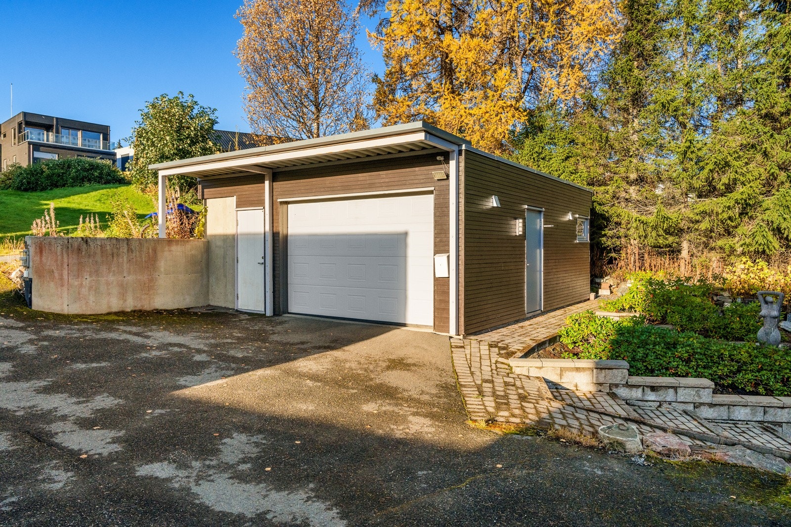 Tilhørende huset har du garasje bestående av tre rom - ett til bilen hvor det også er montert el-billader, et lite rom som i dag brukes som verksted og oppbevaring samt et rom i front for sykkeloppbevaring.