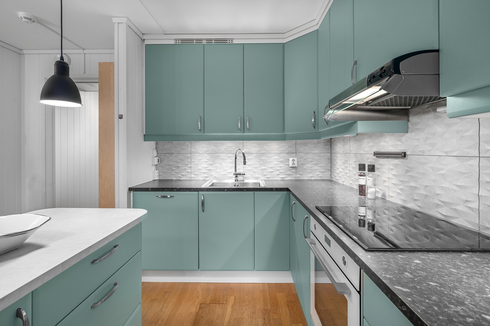 Alt av integrerte hvitevarer medfølger som koketopp med ovn, oppvaskmaskin og kjøleskap med frys. Galleribilde