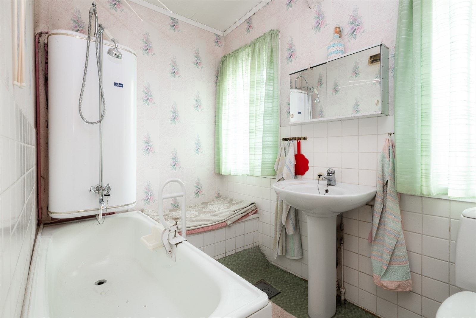 Badet fra byggeår er innredet med søylevask, badekar og toalett. Rommet er naturlig ventilert. Vegghengt varmtvannstank opplyses å være defekt. Galleribilde