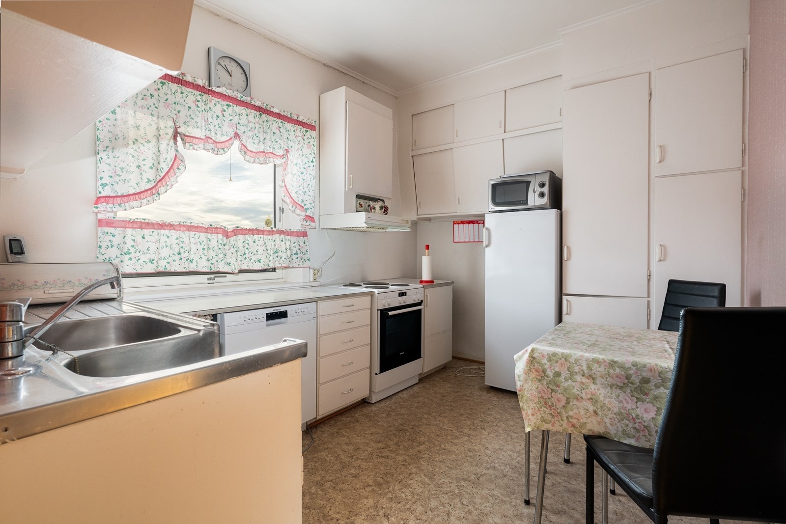 Eldre kjøkken med plassbygget innredning og hyggelig spiseplass. Galleribilde