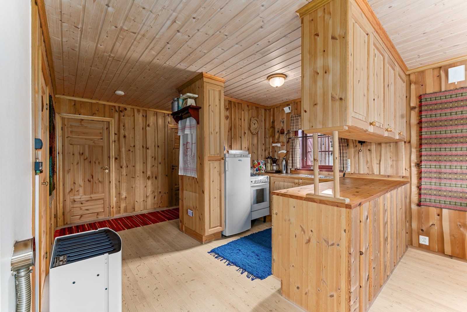 Kjøkkenet har innredning i heltre med profilerte fronter og benkeplate i heltre, som harmonerer fint med resten av interiøret. Her er det en dobbel kjøkkenkum, samt gasskomfyr og gasskjøleskap som medfølger salget. Galleribilde