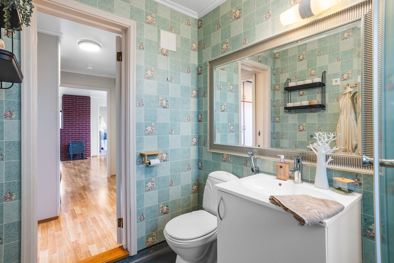 Badet er av eldre dato. Det er belegg på gulv og tapet på vegger. Galleribilde