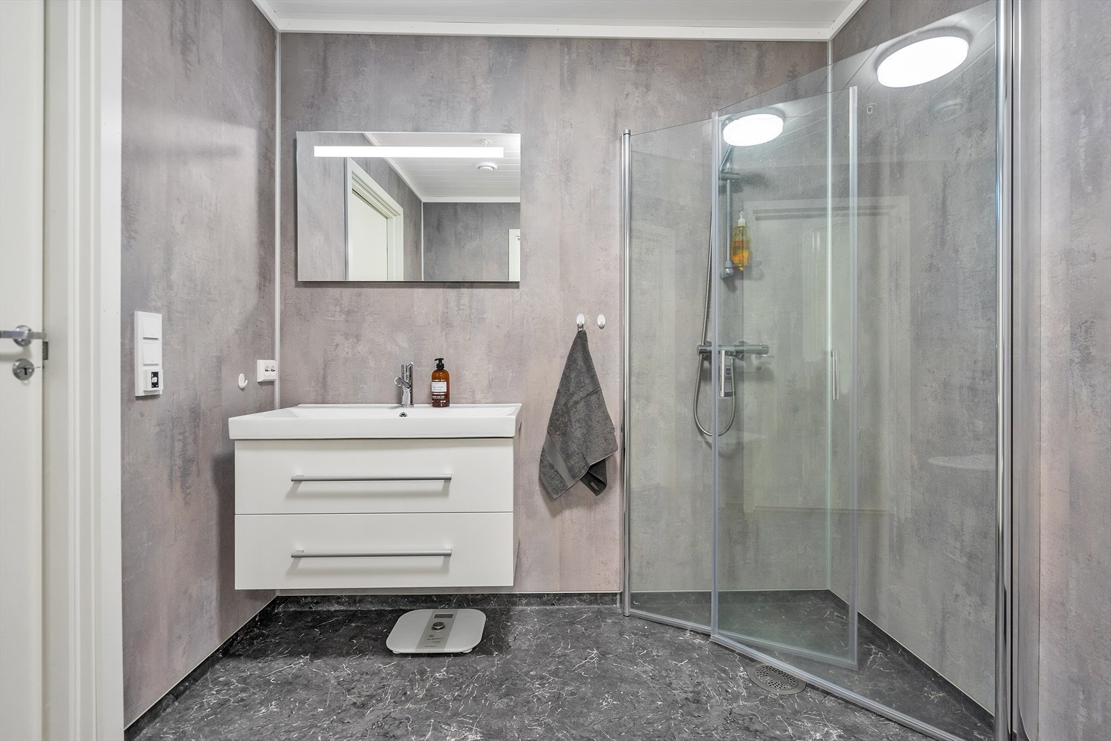 Romslig bad m/belegg på gulv og baderomsplater på veggene, lys baderomsinnredning med underskuffer, dusjhjørne med innfellbare dusjvegger Galleribilde