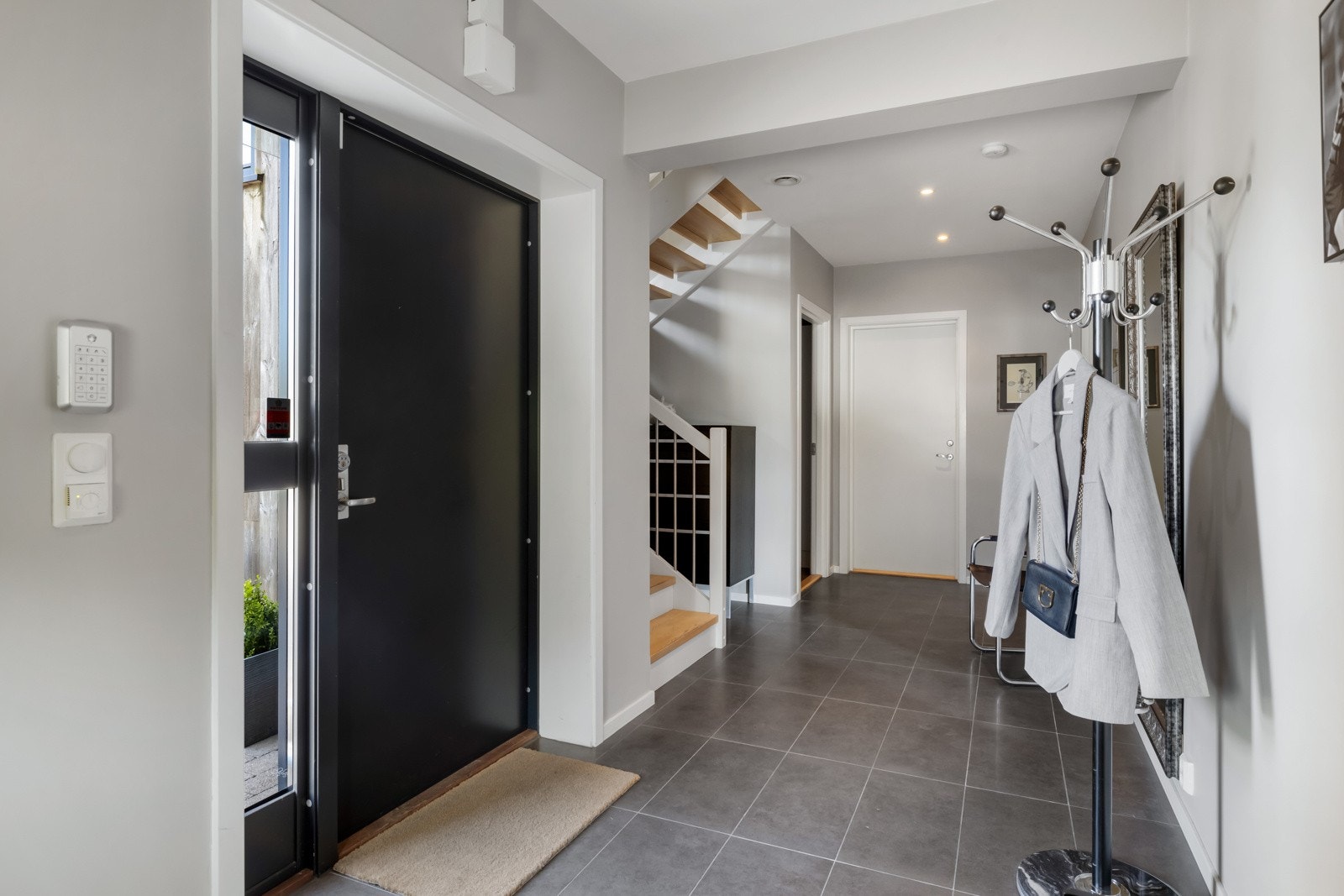 Velkommen inn til en romslig og praktisk entré/gang. Rommet har deliktate fliser på gulv med underliggende varme. Det er innstallert fingeravtrykk-leser på inngangsdør. Galleribilde