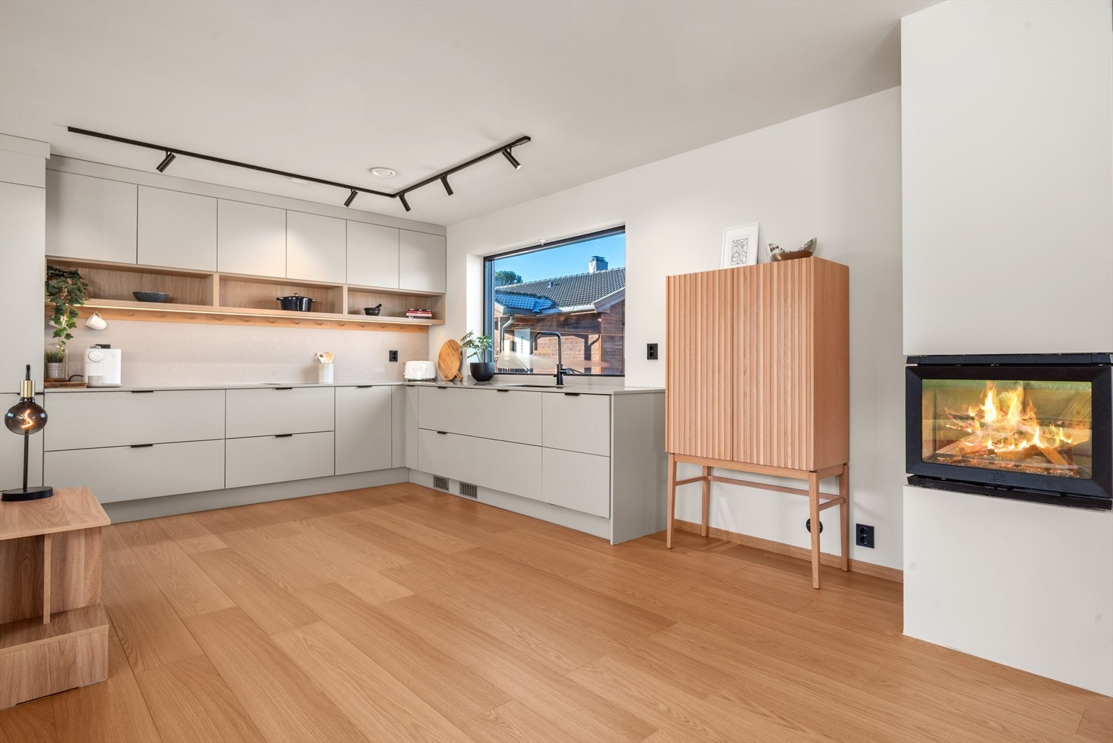 En varm og stor peis fra Jøtul med oppbevaring under Galleribilde