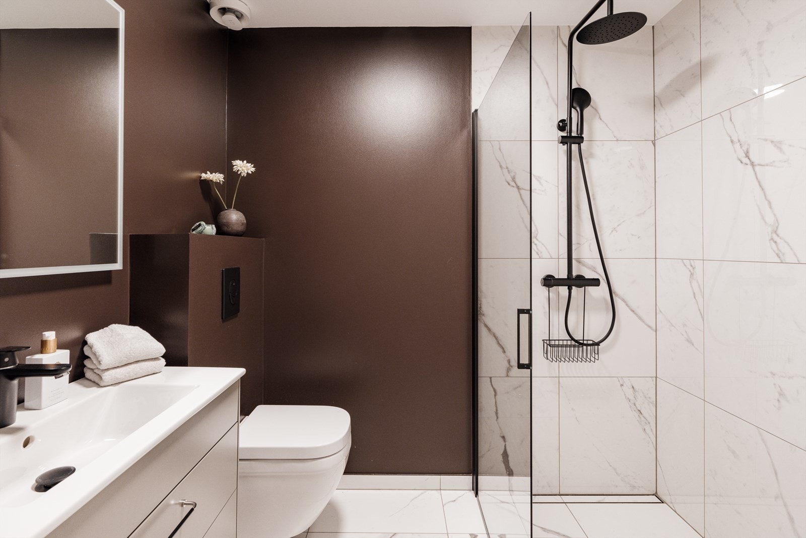 Bad nr. 2 er like lekkert som hovedbadet - perfekt for gjester eller familiens ungdom. Rommet har servantinnredning med lysegrå skuffer og speil i samme stil som på hovedbadet, noe som skaper et helhetlig og moderne uttrykk. Galleribilde