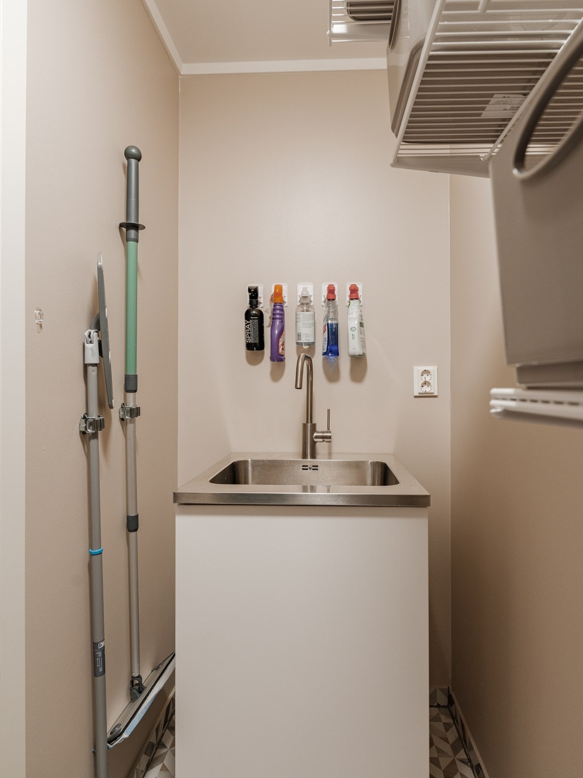 Rommet er innredet med et hvitt benkeskap og nedfelt utslagsvask i stål - en funksjonell og ryddig løsning som gjør klesvasken både enklere og mer effektiv. Galleribilde