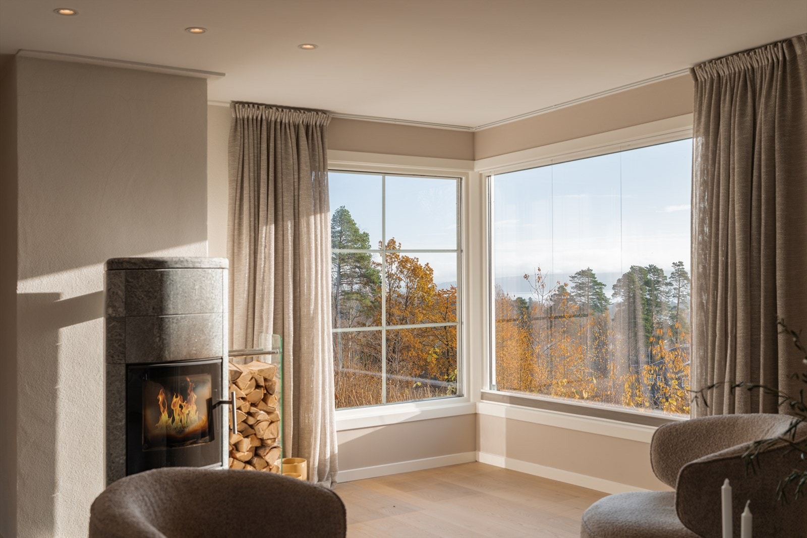 Et stort hjørnevindu ivaretar utsikten, og lune kvelder sikres av en ny klebersteinsovn, plassert slik at stemningen nytes fra hele rommet. Galleribilde
