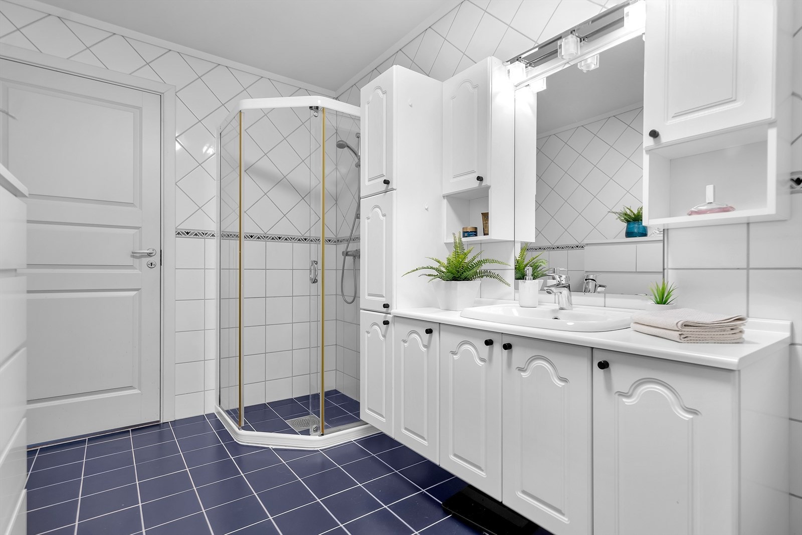 Inneholder baderomsinnredning med vask og speil, dusjvegger/hjørne og toalett. Galleribilde