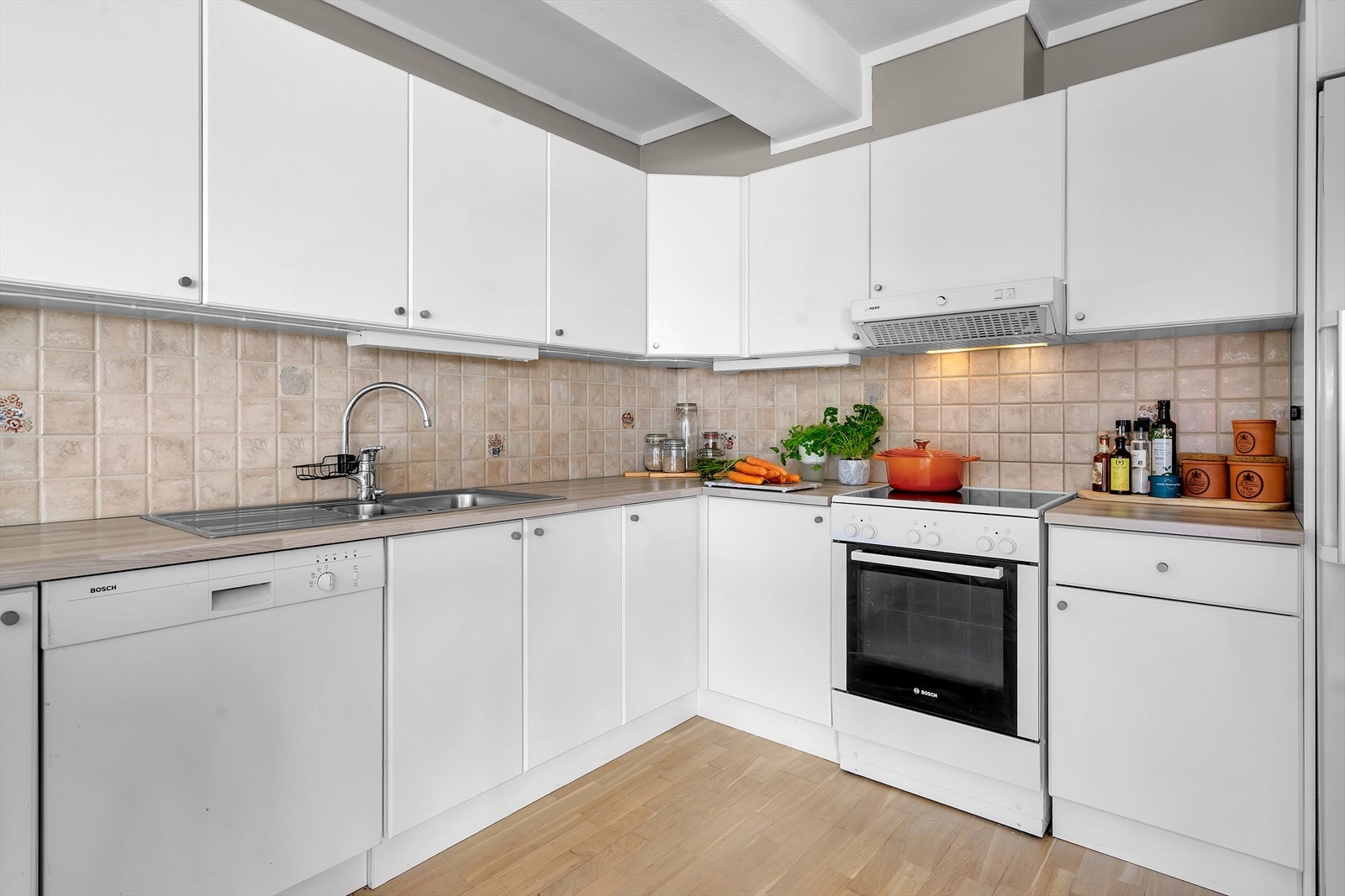 Laminert benkeplate, fliser mellom benkeplate og overskap. Kjøleskap medfølger i handelen. Galleribilde