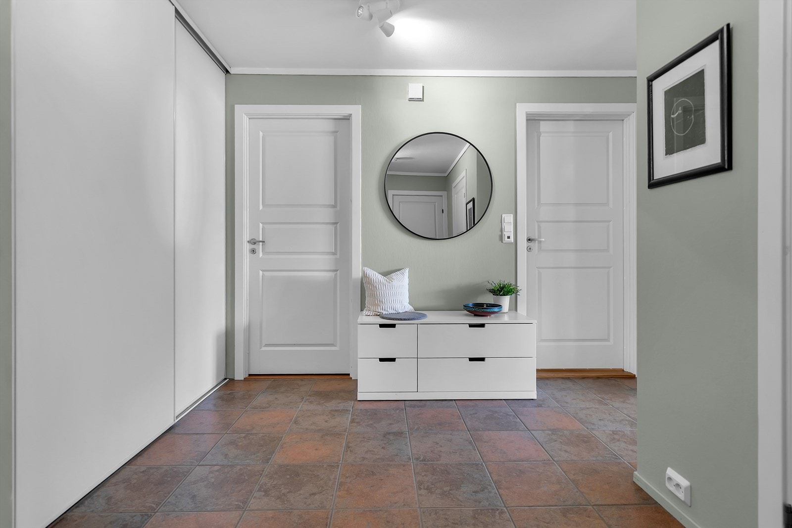 Innbydende gang med flislagt gulv med varme og skyvedørsgarderobe. Galleribilde