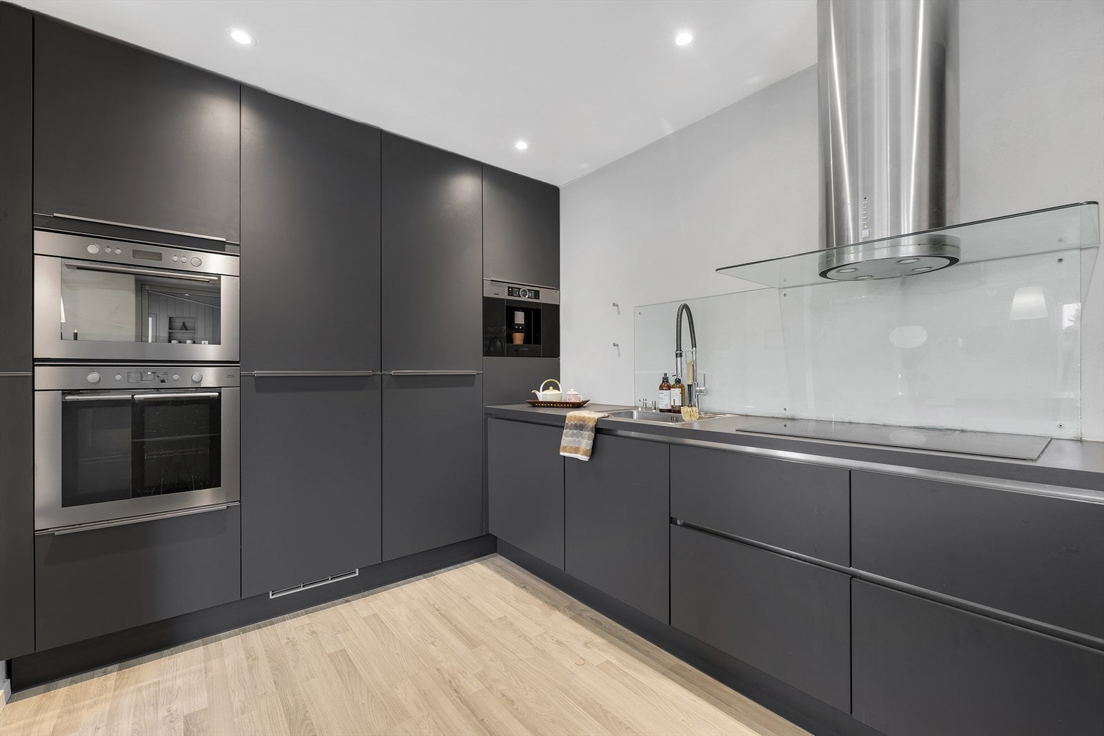 Kjøkkenet har innredning bestående av underskap og høyskap med folierte fronter og skrog. Laminat benkeplate med nedsenket oppvaskkum og platetopp. Galleribilde