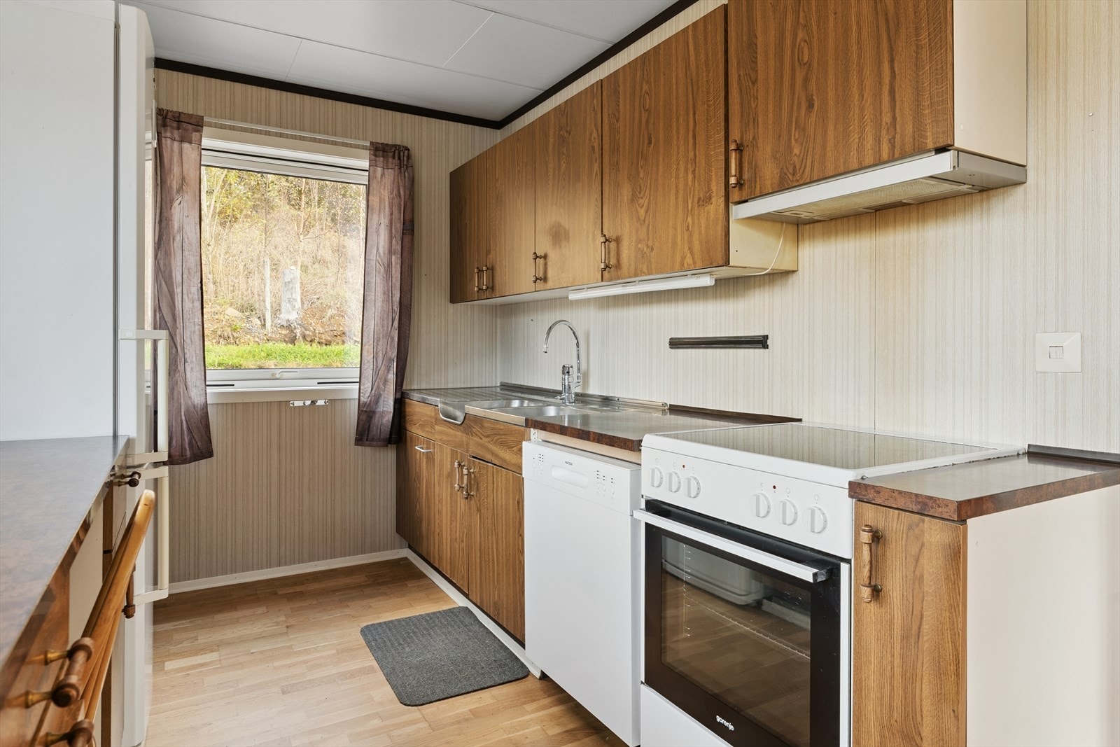 Vindauge ut mot steinbelagt tun på bakside av huset Galleribilde