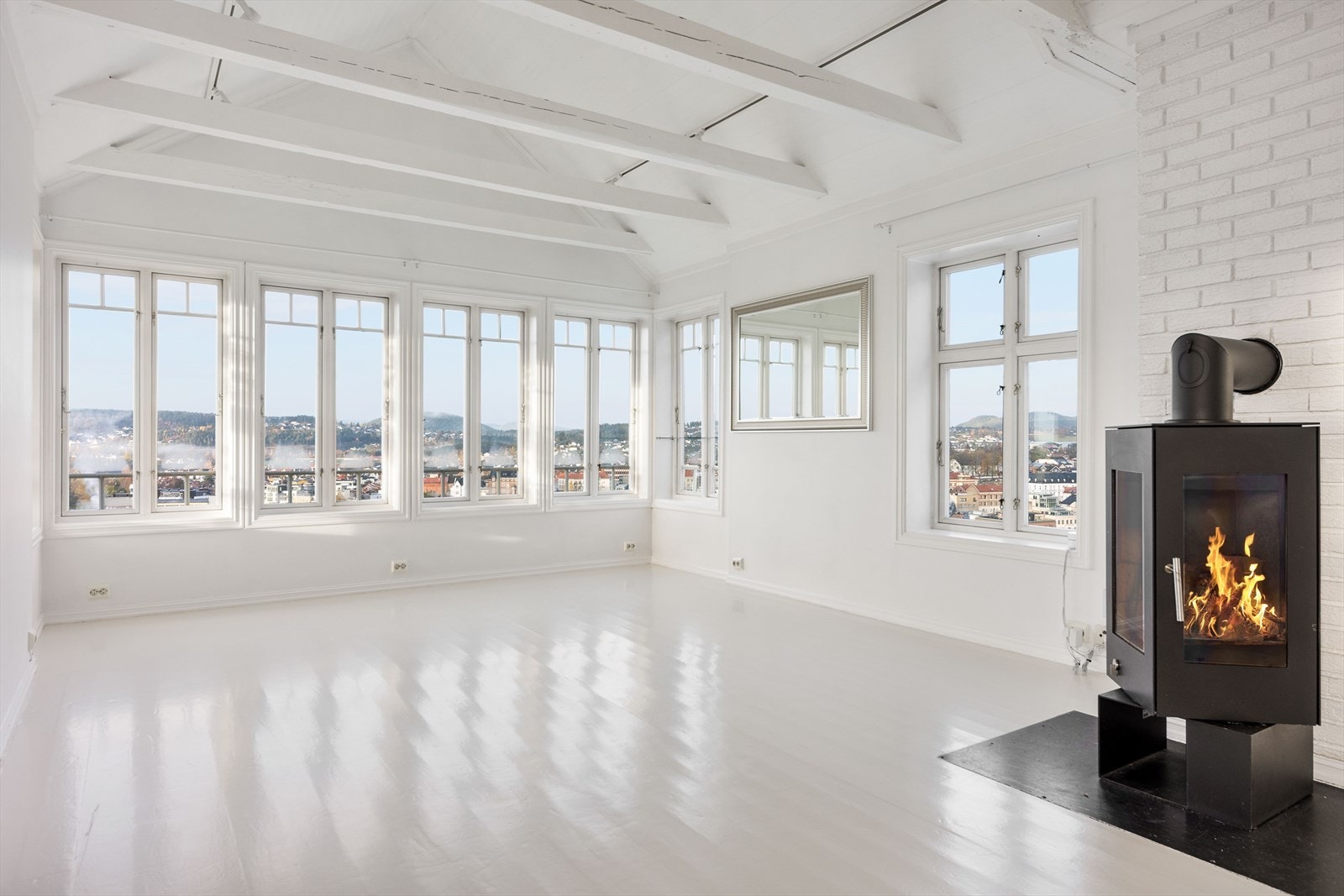 Sentralt i stuen er det montert peisovn med glass i døren som gir hyggelig innsyn til flammene. Galleribilde