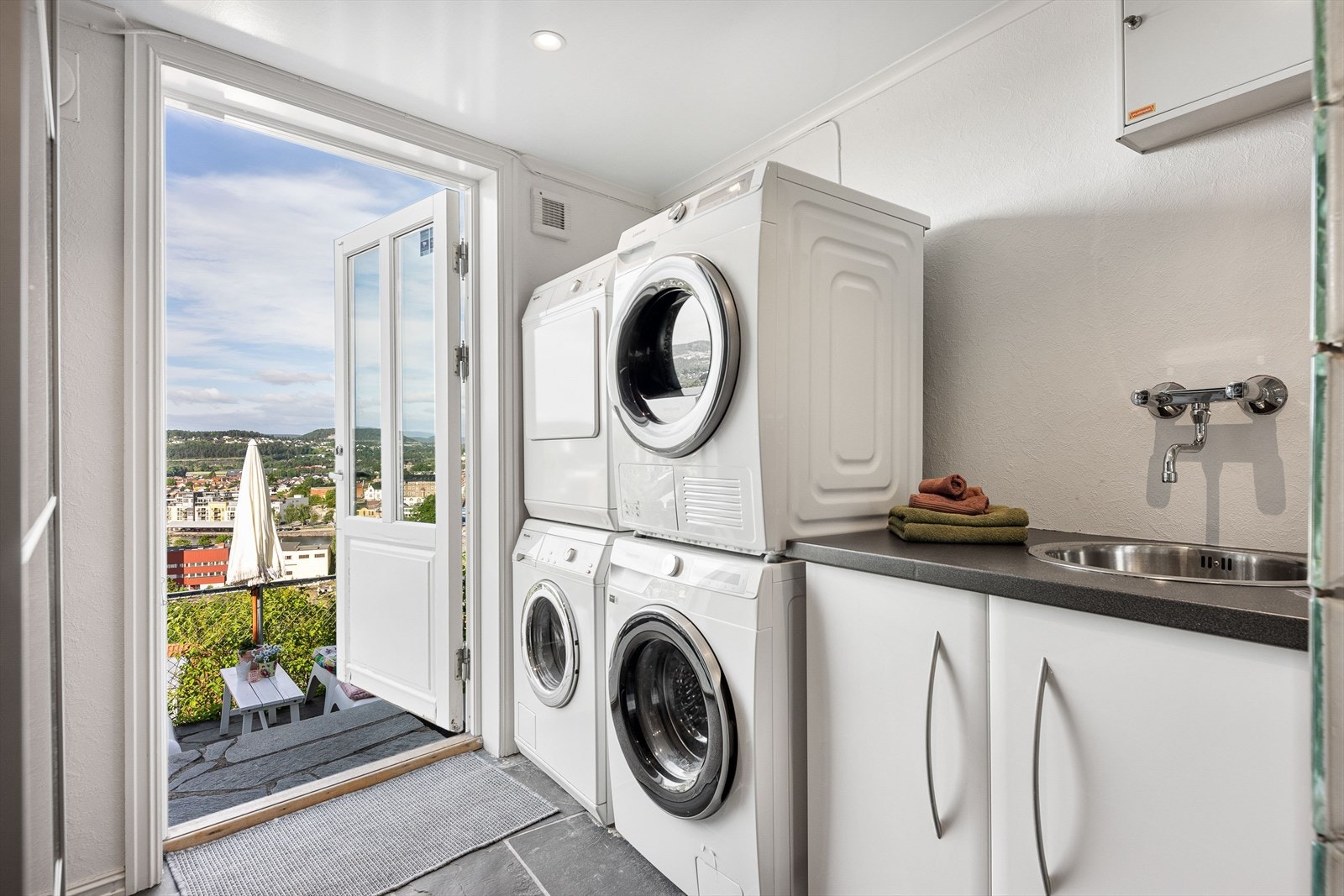 Badet er delt inn i egen sone med vegger i glassbyggerstein med vaskerom bak. Her er det opplegg til oppvaskmaskin og underskap med slett innredning og benkeplate med nedfelt vask Galleribilde