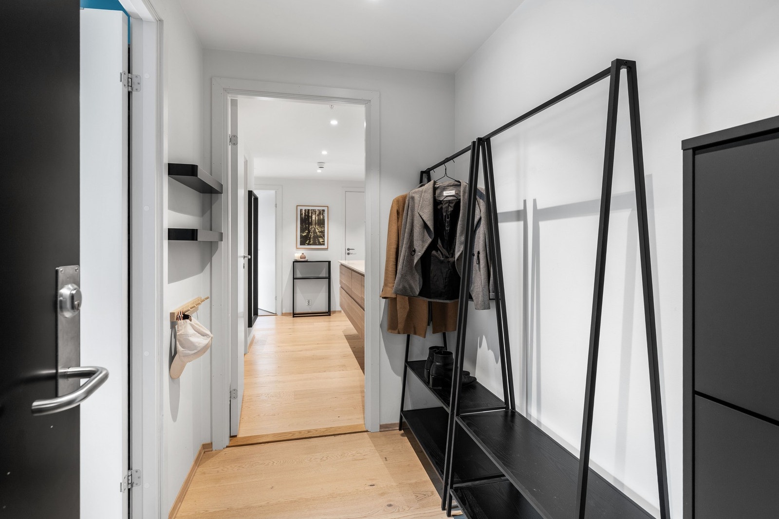 Vel inne har leiligheten en entré med tilliggende gang, der begge rommene er innredet med downlights og 1-stavs parkettgulv. Galleribilde