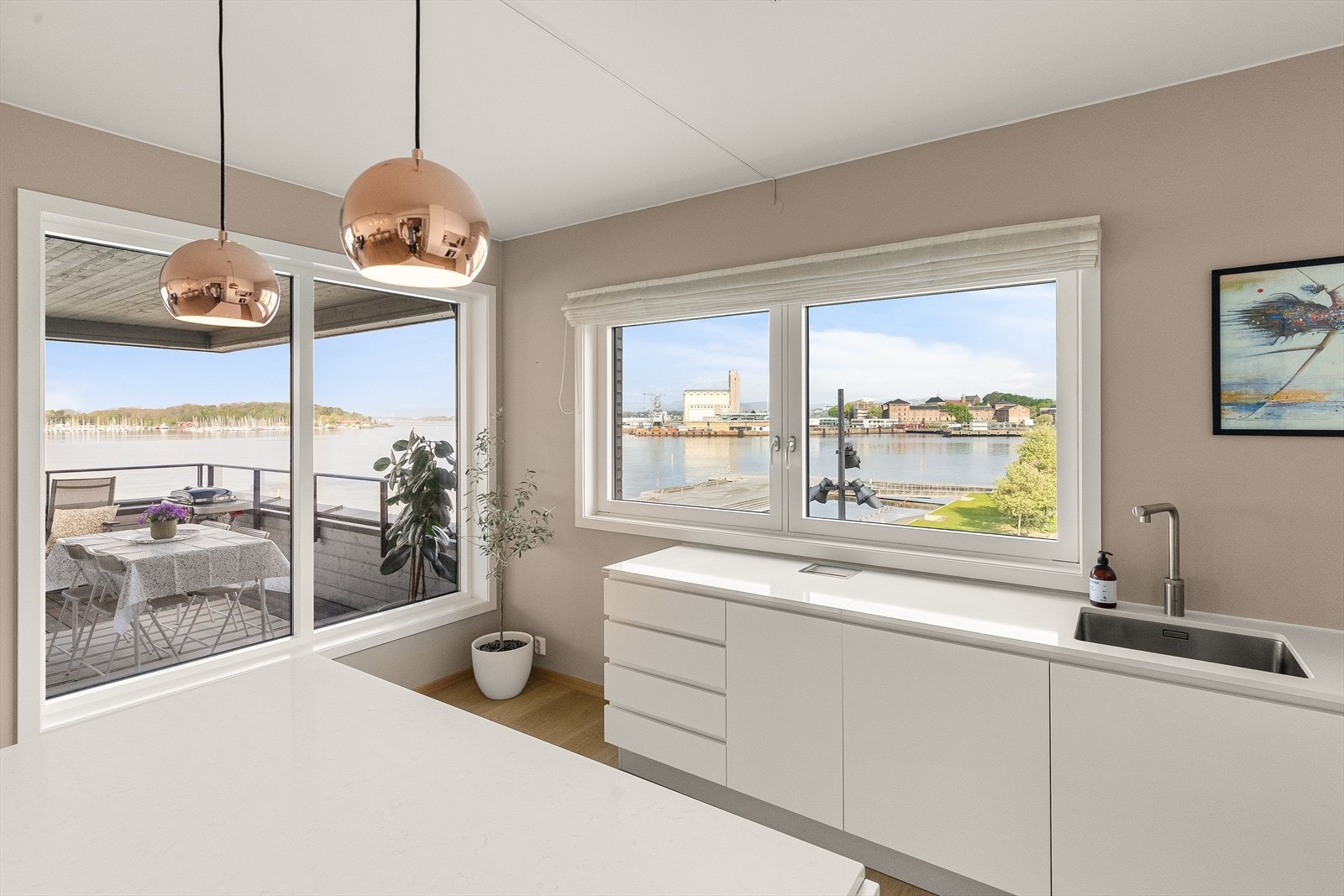 Lekkert kjøkken med slette flater, kompositt og Corian benkeplate. Galleribilde