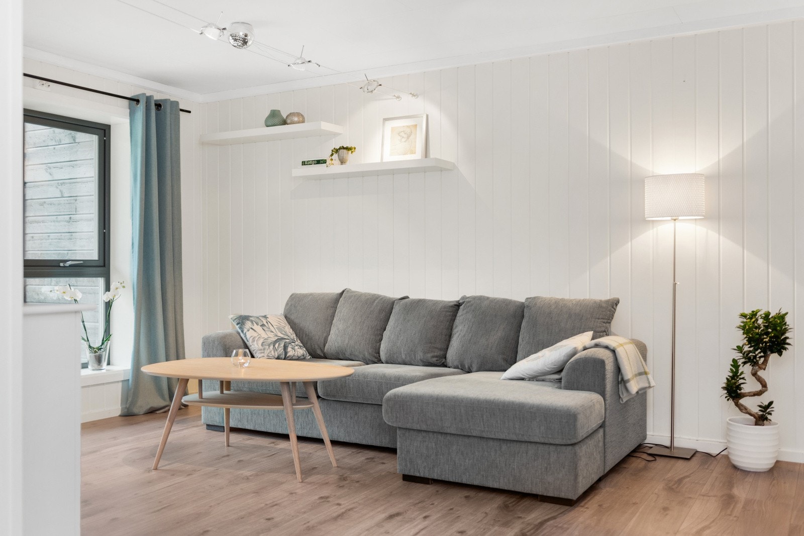 Store vindusflater i stuen sørger for rikelig med naturlig lys til rommet. Galleribilde