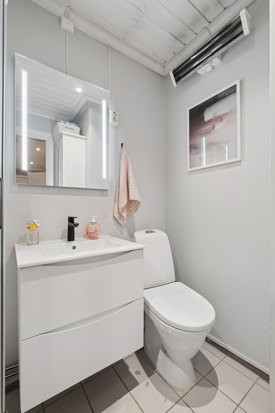 Bad utstyrt med opplegg for vaskemaskin, dusjkabinett, servantinnredning og wc på sokkel. Galleribilde