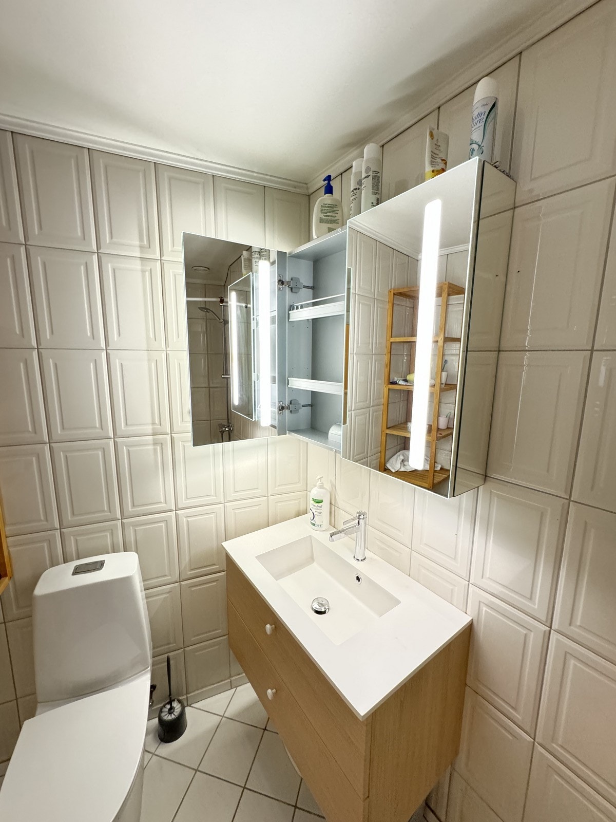 Badet inneholder dusjhjørne, toalett, servant med underskap og speilskap. Galleribilde