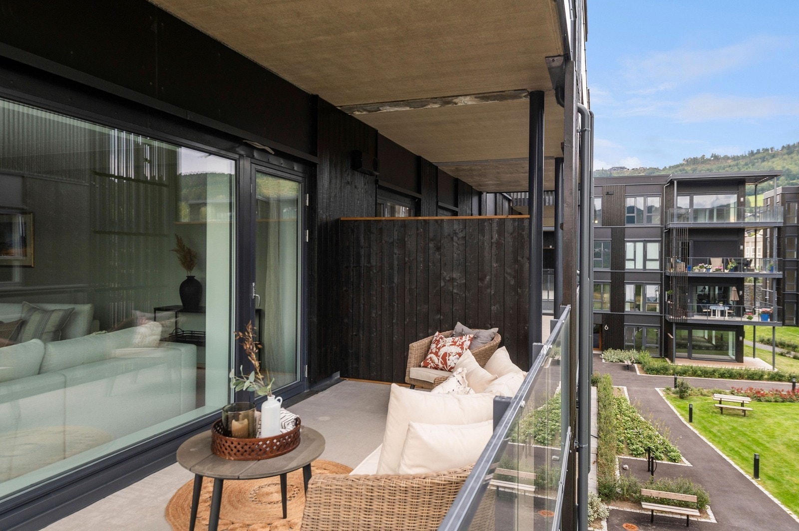 Balkongen har glassrekkverk og plass til hyggelig sittegruppe. Galleribilde