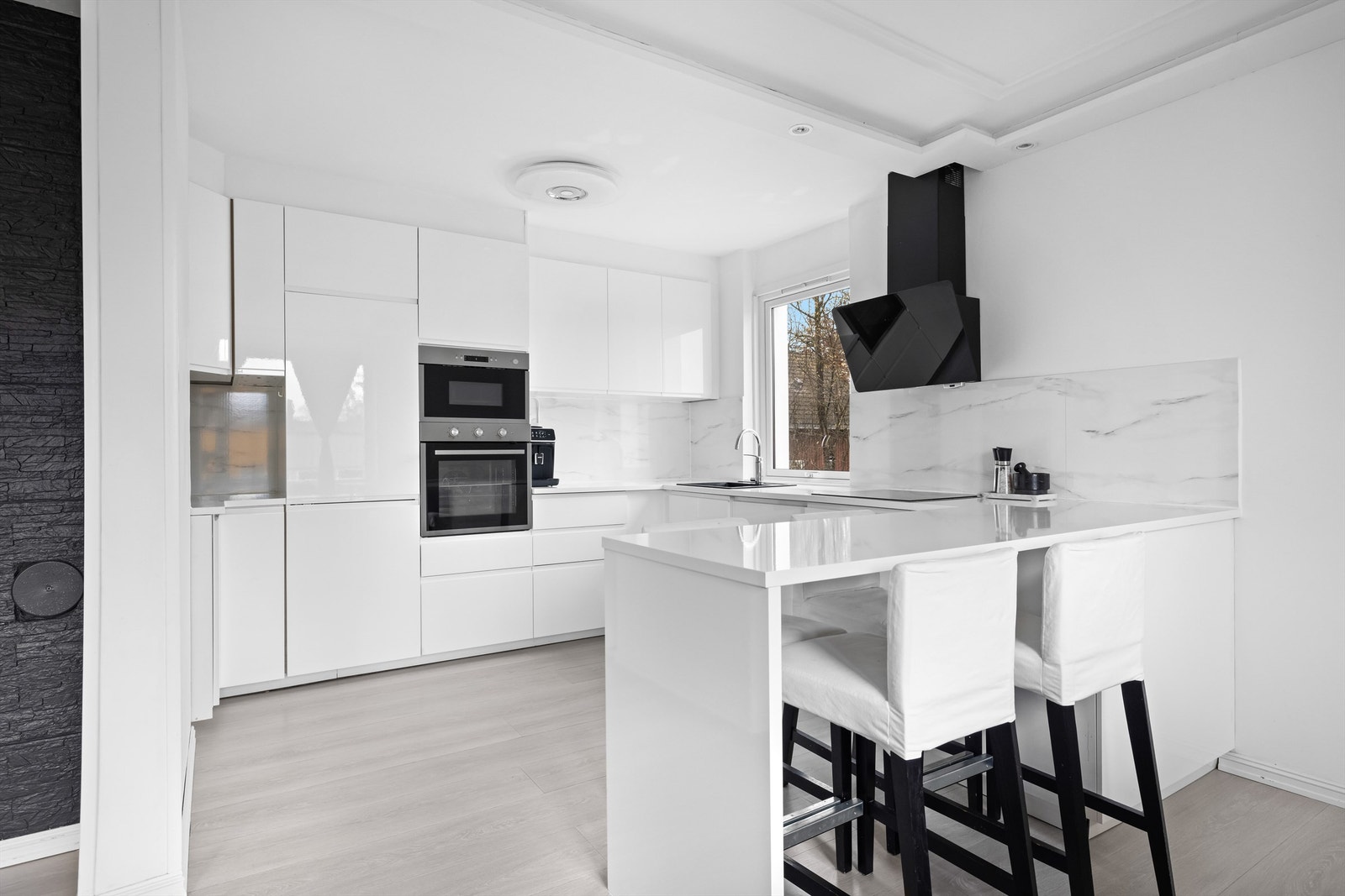 Her møtes du av et stilrent kjøkken med en praktisk kjøkkenøy som et sosialt samlingspunkt. Galleribilde