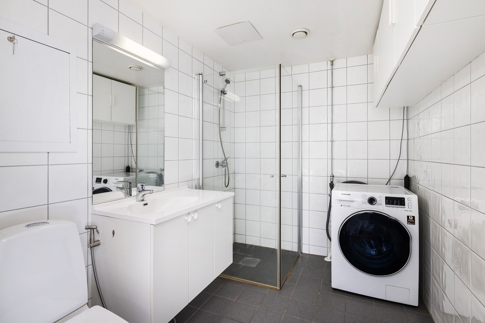 Flislagt bad med opplegg for vaskemaskin. Galleribilde