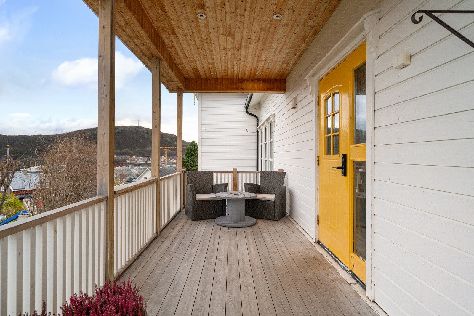 Takoverbygd inngangsparti med plass for utemøbler og beplantning.