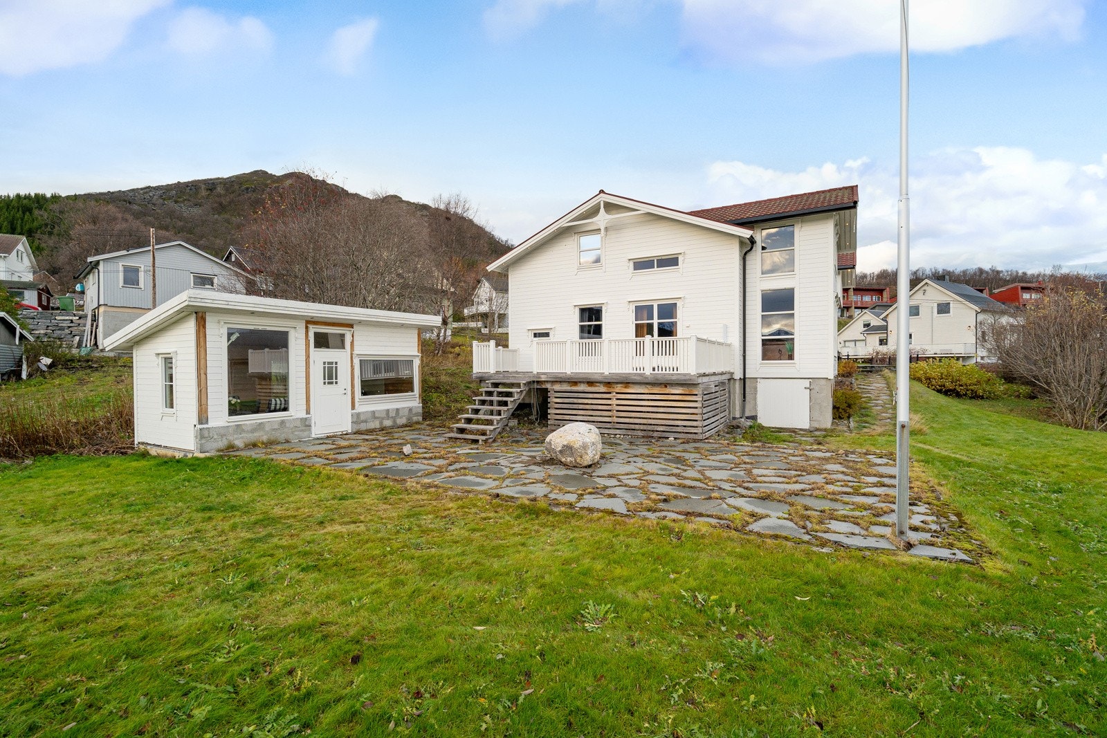 Flott hage delvis opparbeidet med stein. Stor boltreplass på plen!