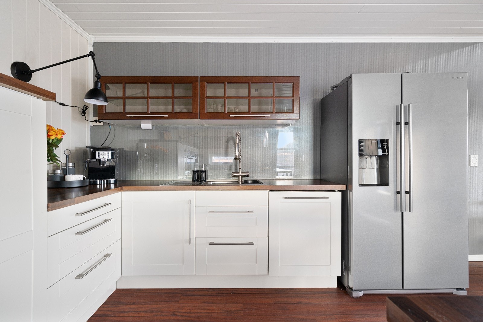 På kjøkkenet får du kvaliteter som belysning under overskap og glassplate på vegg.