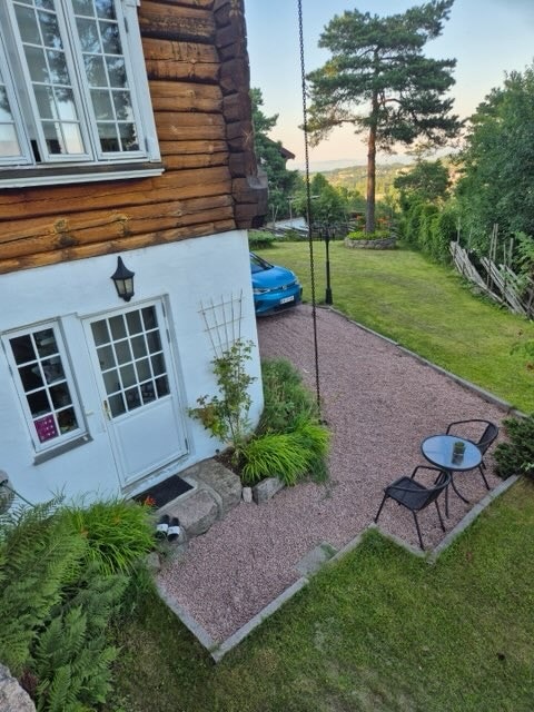 Uteplass hvor biloppstillingsplassen skimtes på hjørnet. Galleribilde