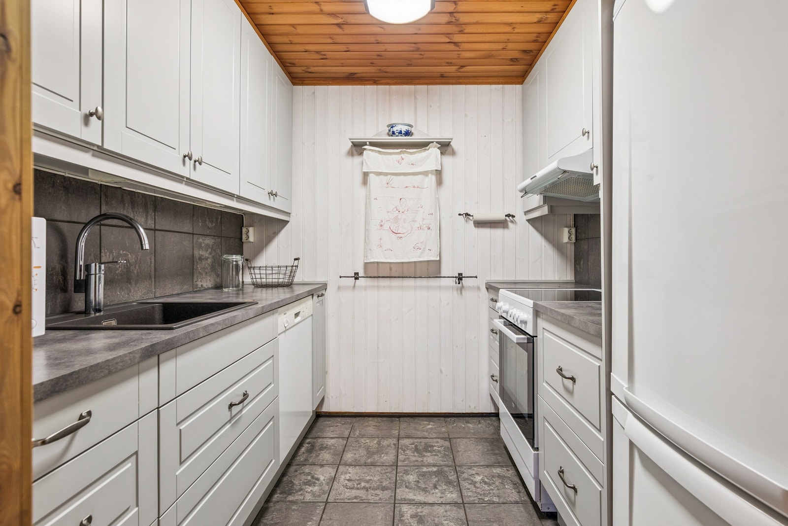 Kjøkkenet i hovedhytta er praktisk innredet med godt med skap- og benkeplass. Galleribilde