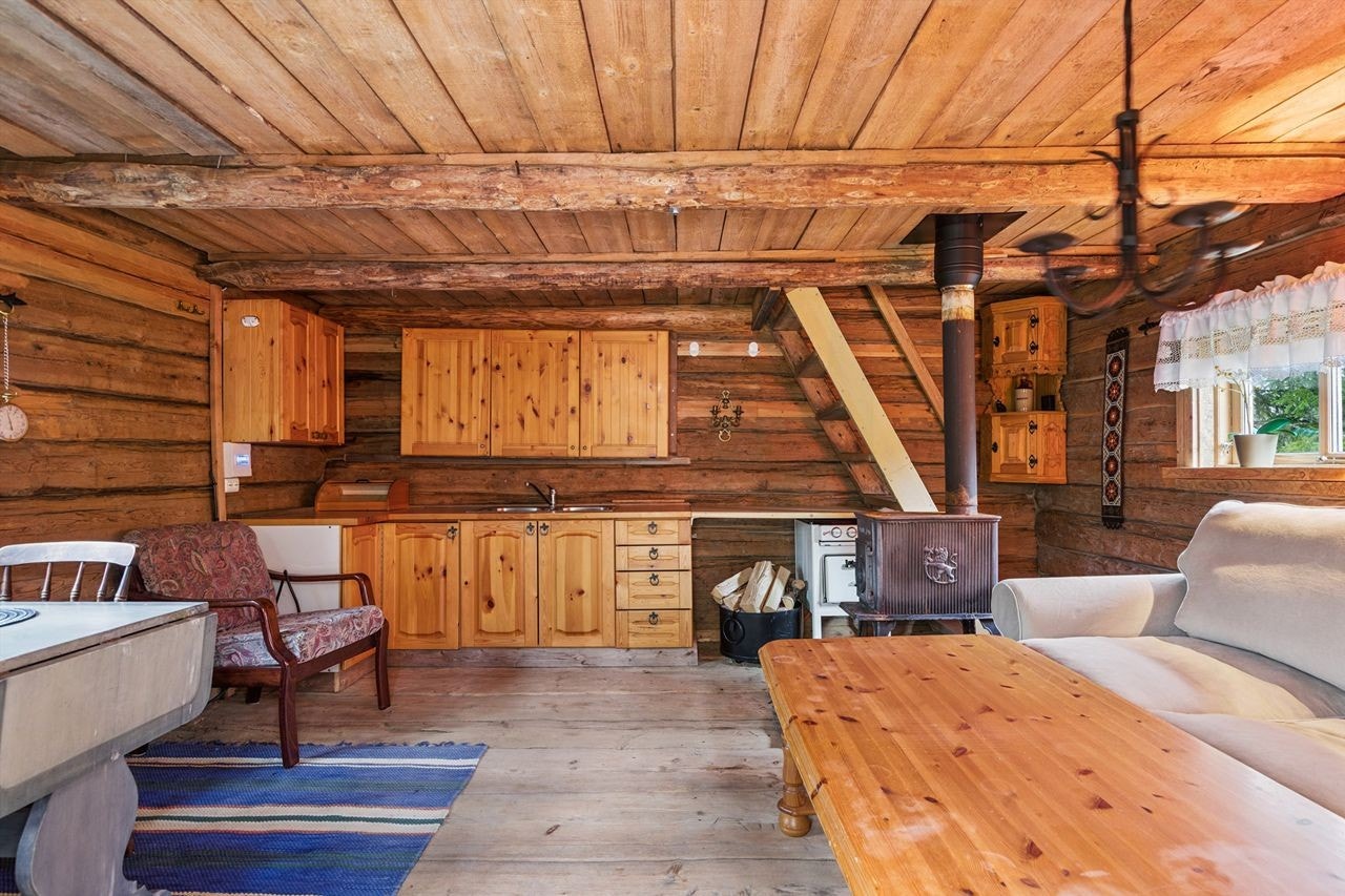 Det røde stabburet er innredet over to etasjer med kjøkkenkrok og vedfyring. Galleribilde