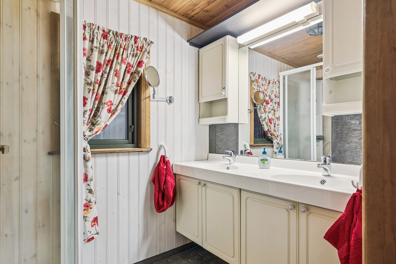 Badet er utstyrt med dusjkabinett og en dobbel servant med oppbevaringsplass. Galleribilde