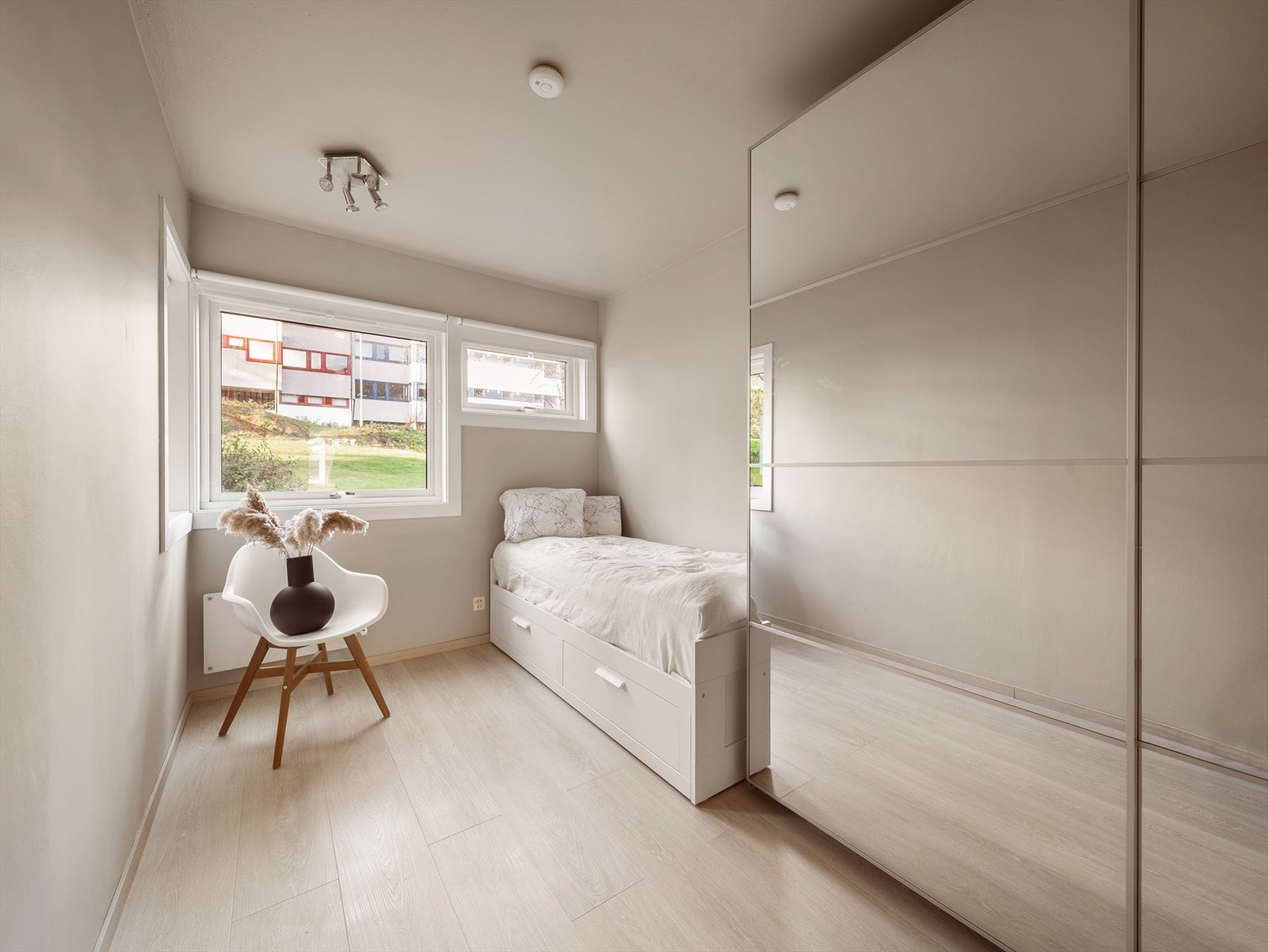 Lyst soverom med store vinduer som gir rommet godt med naturlig lys. Det er god plass til å innrede rommet med seng, nattbord og skrivepult. Galleribilde