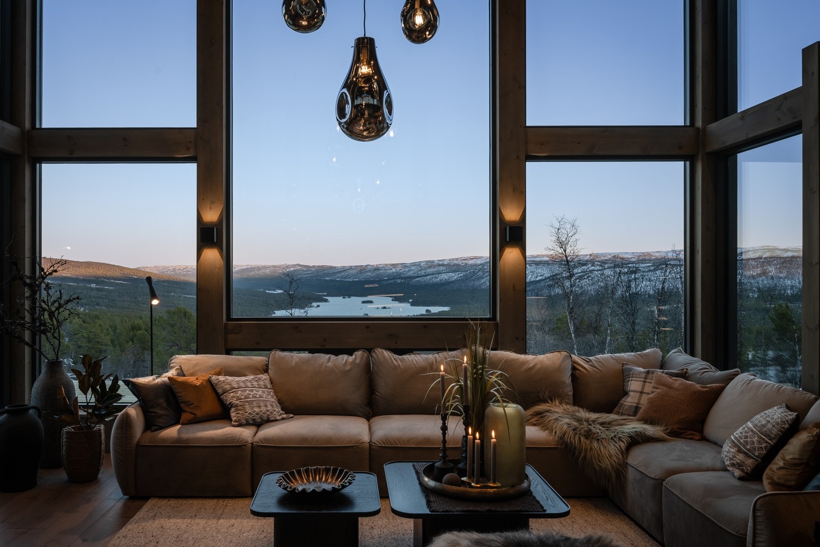 Hytten har store vindusflater som slipper naturen inn og gir en magisk utsikt Galleribilde
