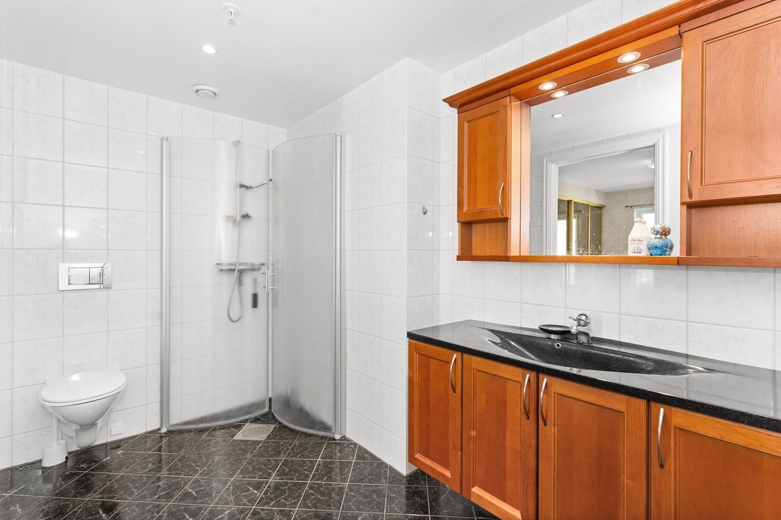 Badet er innredet med dusjnisje og en stor baderomsinnredning Galleribilde