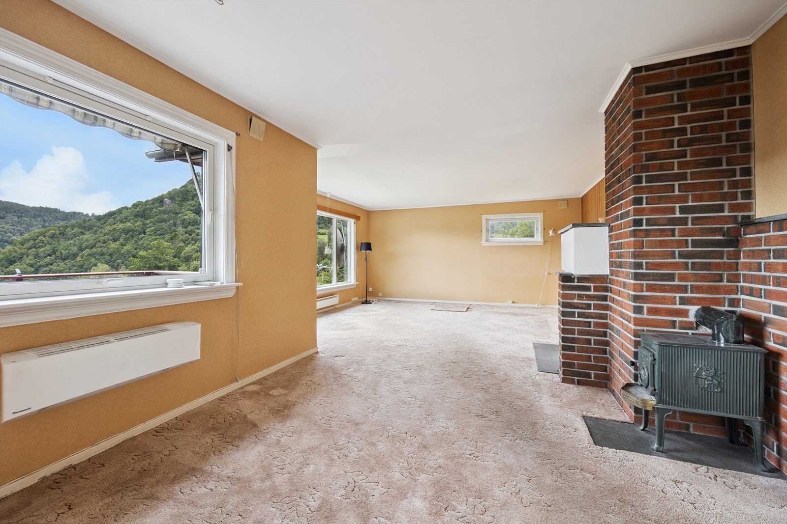 I stua er det en vedovn og en åpen peis. Galleribilde