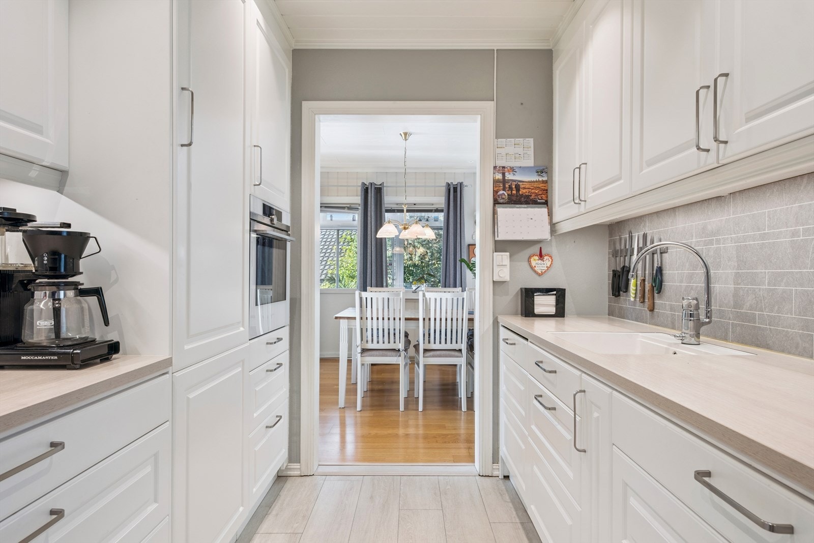 Lekkert og tidløst kjøkken fra Drømmekjøkkenet med rikelig benkeplass og integrerte hvitevarer Galleribilde