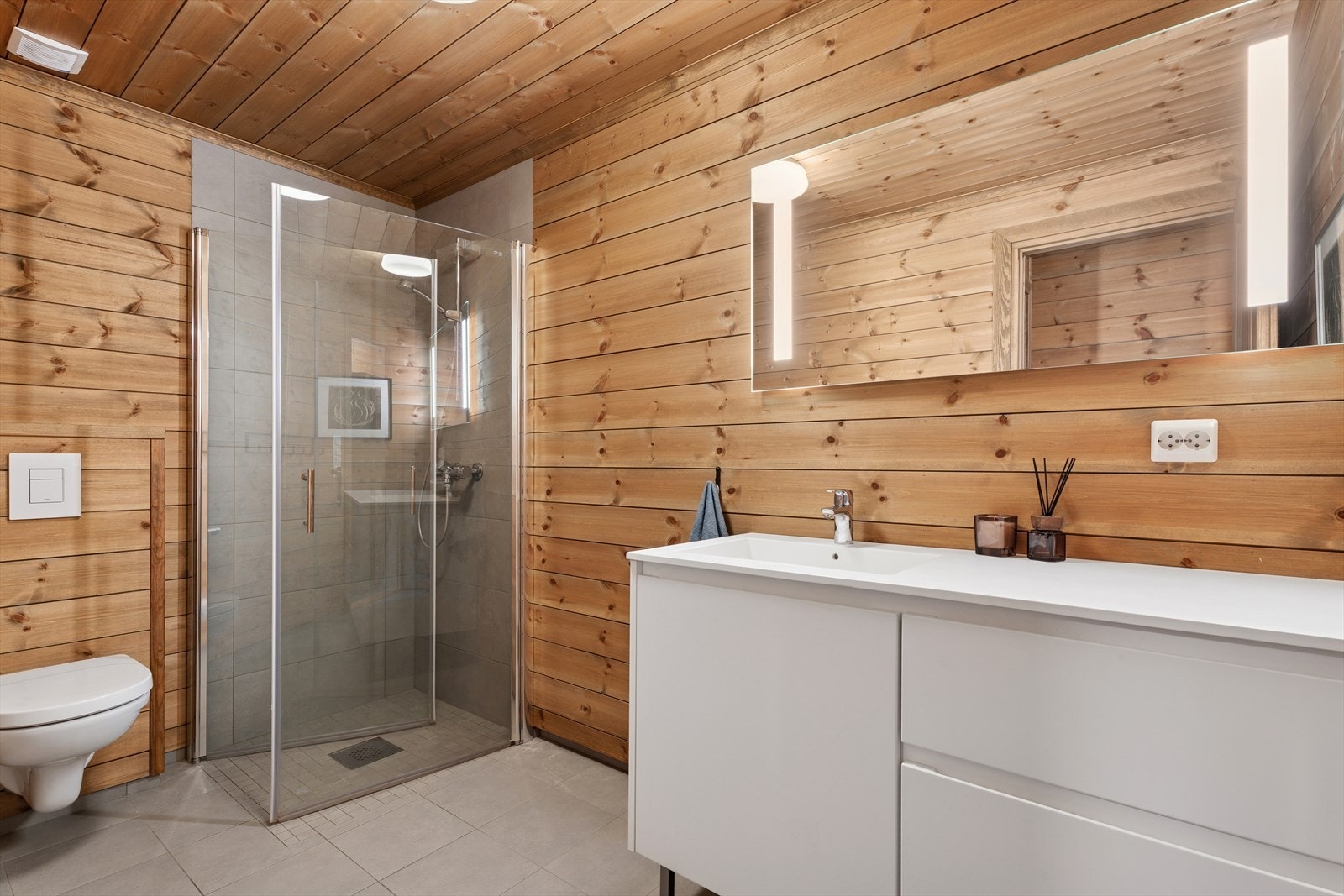 Badet har innvendige overflater med panel på vegger og i tak, samt flislagt gulv med gulvvarme. Galleribilde