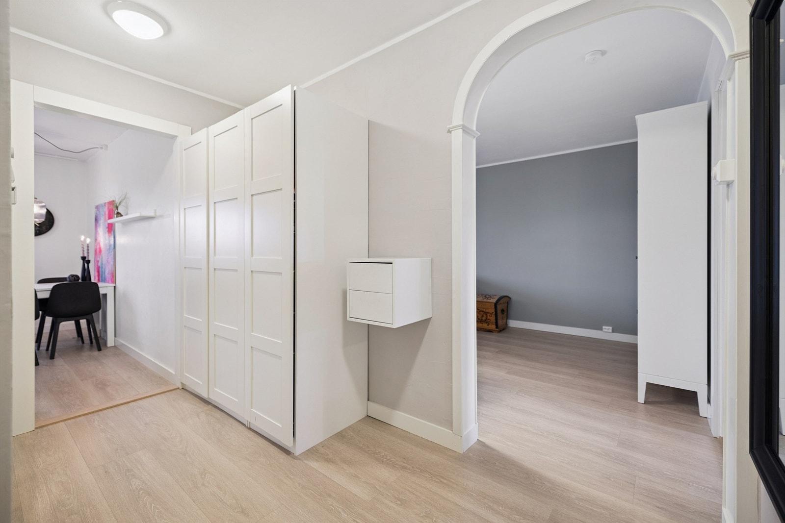 Fra gangen åpner leiligheten seg opp, med en buet åpning som leder inn mot stuen. Galleribilde