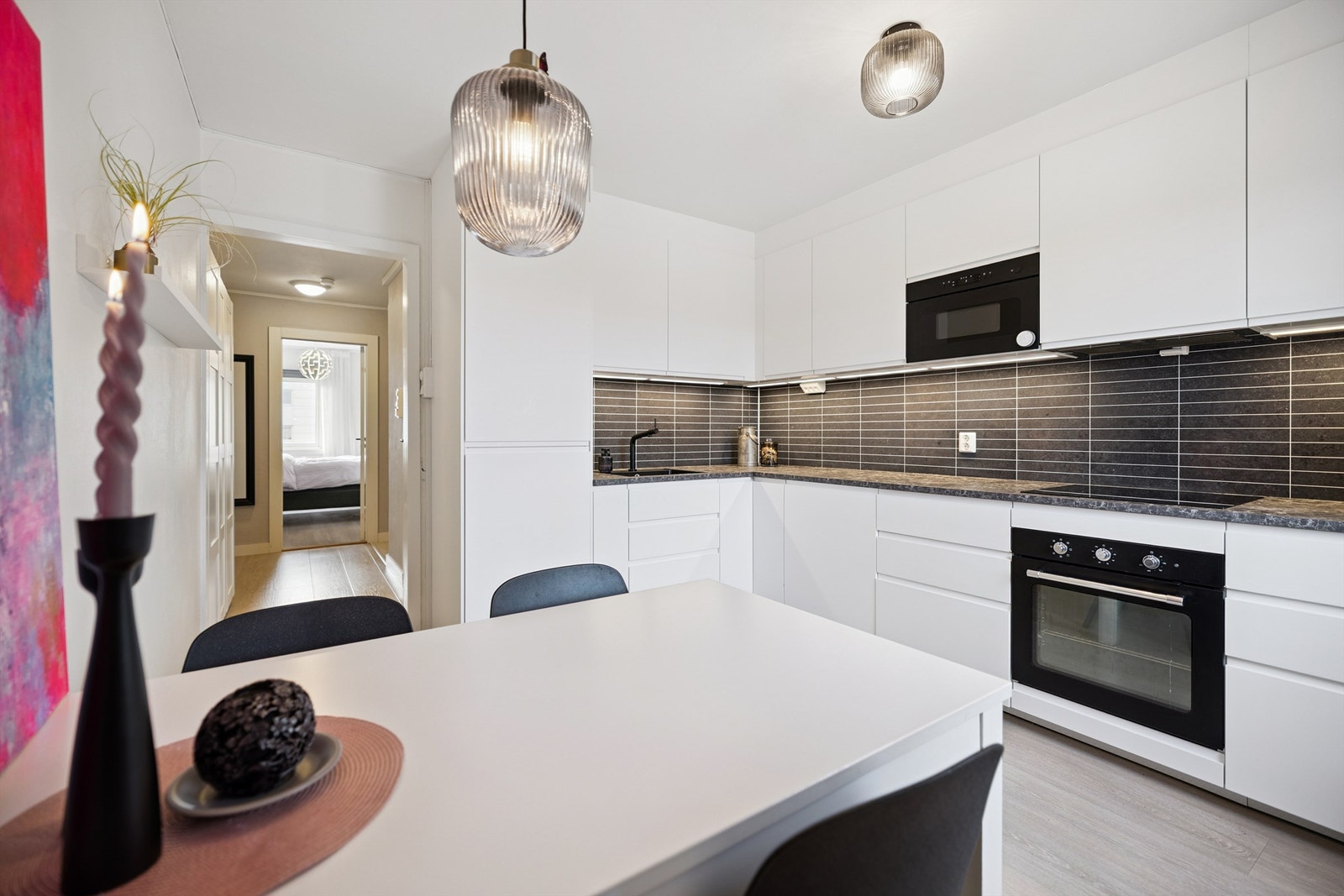 Kjøkkeninnredningen har glatte, hvite fronter og godt med skap- og skuffeplass. Galleribilde