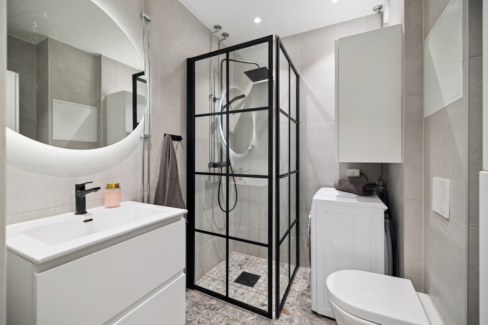 Her er det varmekabler i gulvet, vegghengt toalett og et dusjhjørne med innfellbare glassdører. Galleribilde