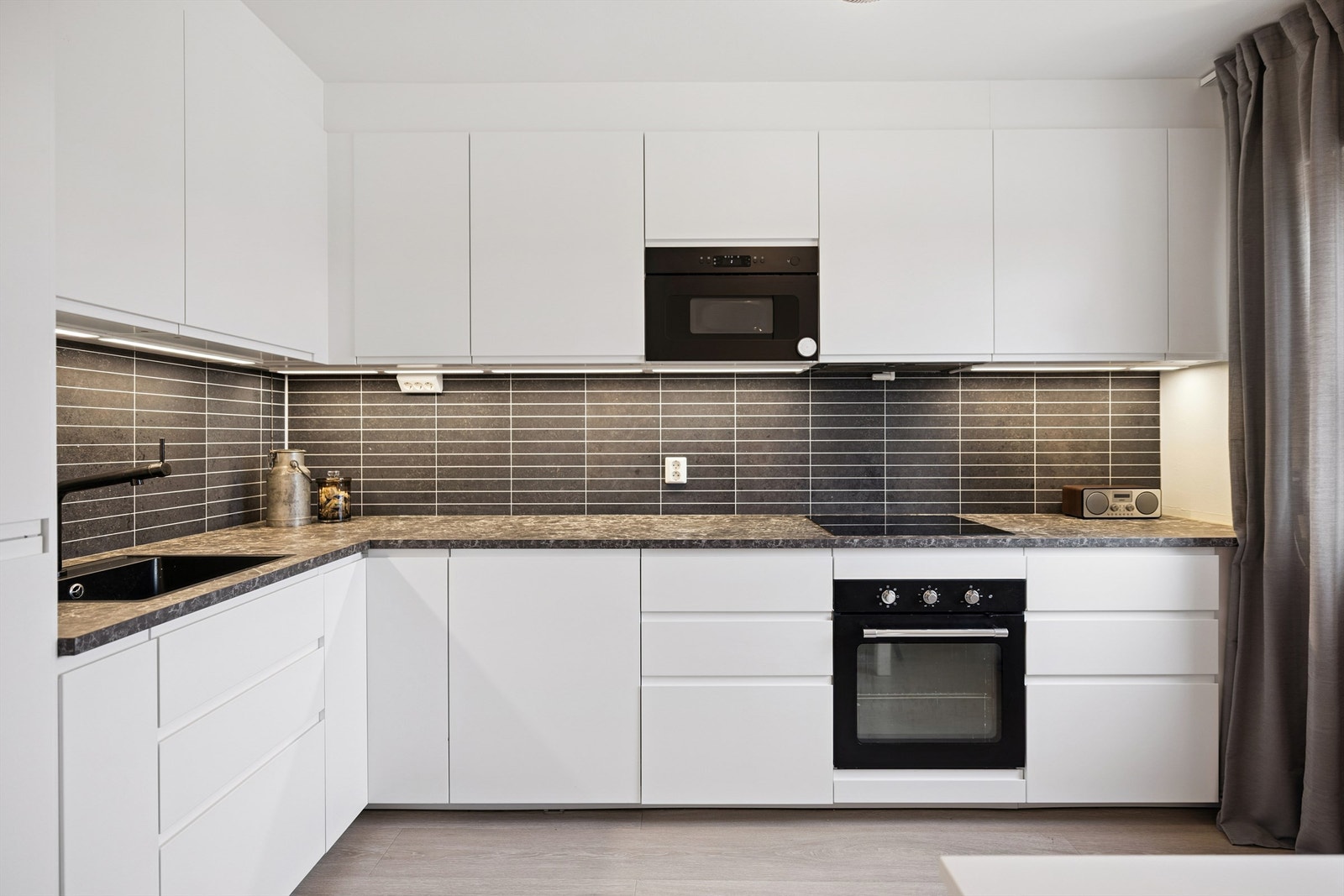 Kjøkkenet fra IKEA er stilrent og praktisk, med integrerte hvitevarer og godt med benkeplass. Galleribilde