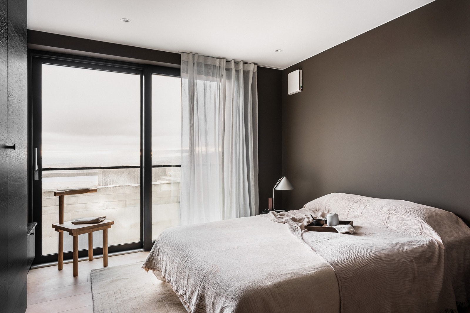 Leiligheten har tre innbydende soverom med gjennomført og helhetlig uttrykk. Her fra soverom 2, med fantastisk utsikt over fjorden og byen. Galleribilde