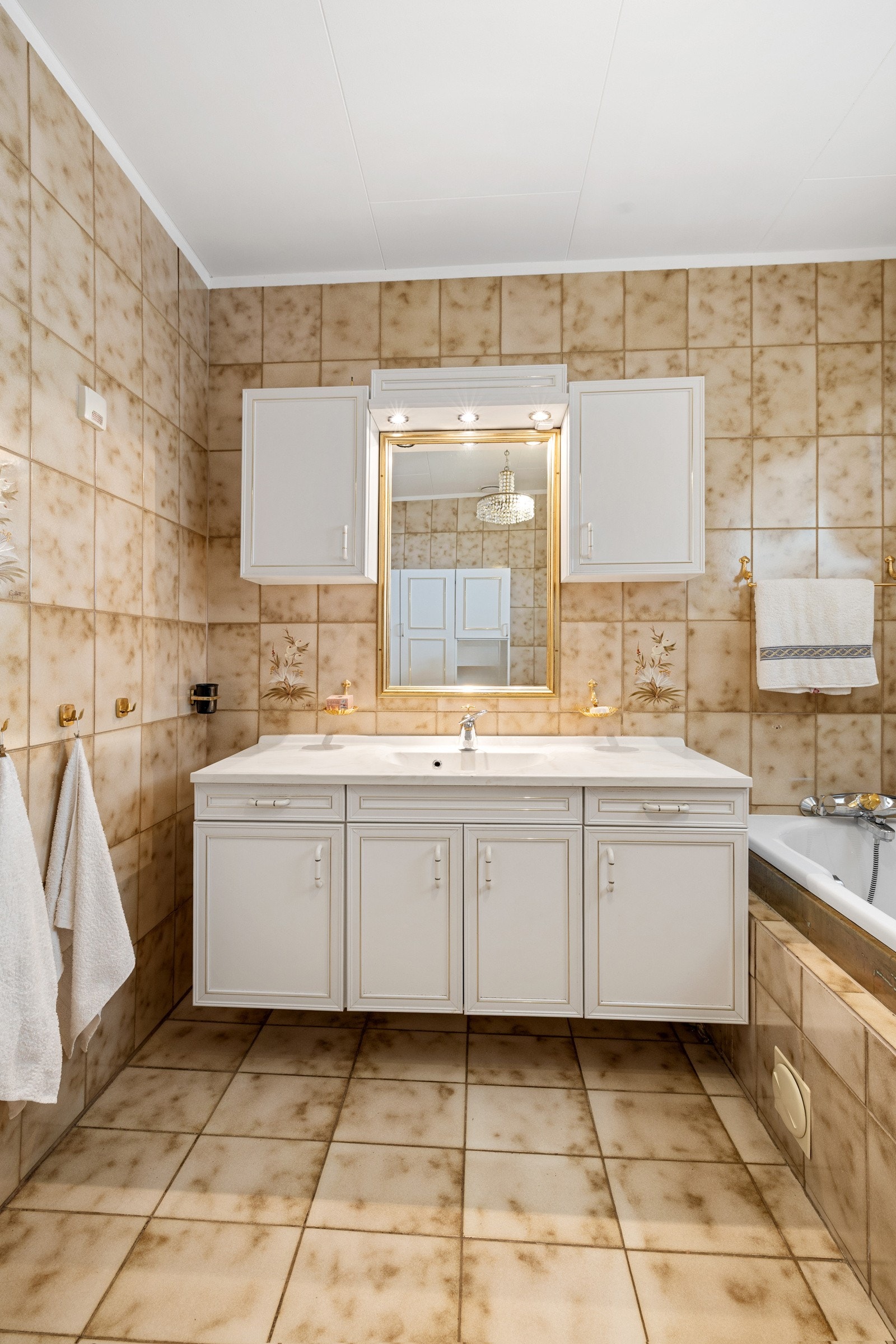 Innredet med servantskap, toalett og innebygd badekar. Galleribilde